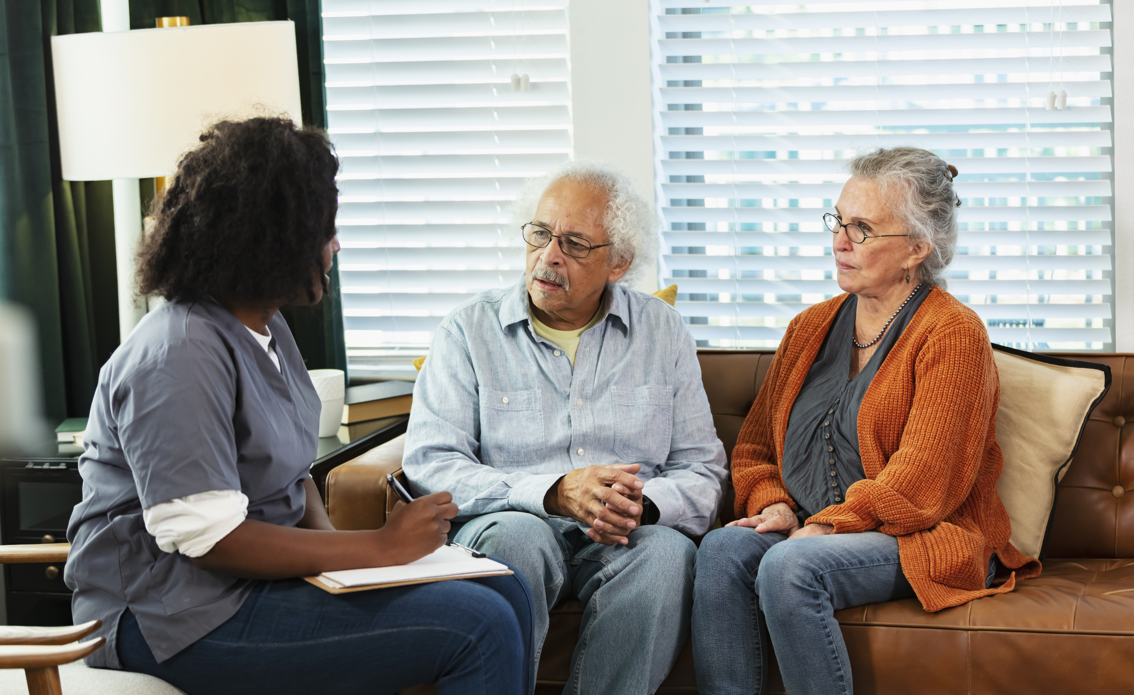 Seniors discussing medical coverage with nurse