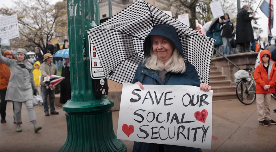 senior woman holding sign saying "Save our Social Security"